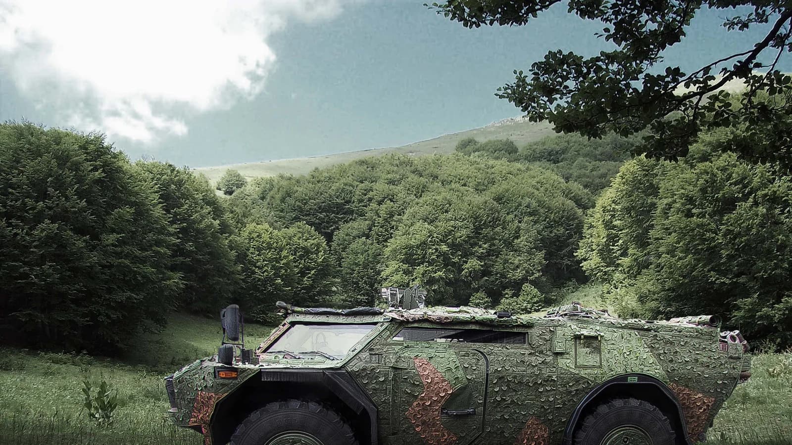 A Fennek reconnaissance vehicle covered in Saab Barracuda woodland-pattern mobile camouflage