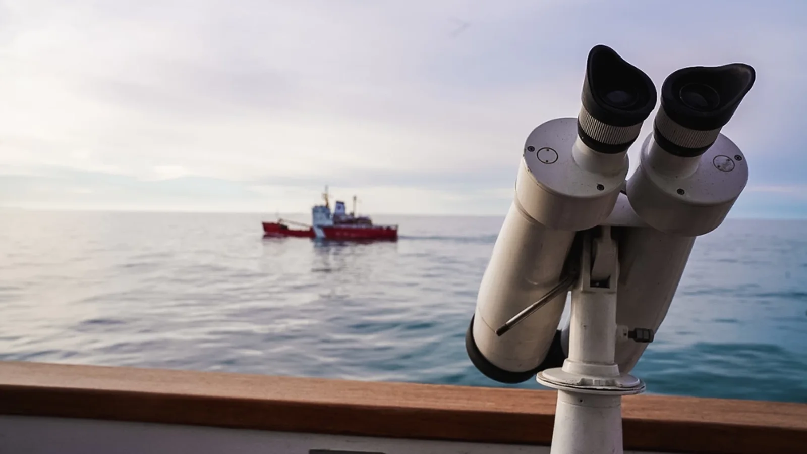 Binoculars aboard a U.S. Coast Guard cutter overlook CCGS Sir Wilfrid Laurier during an Arctic exercise in October 2022.