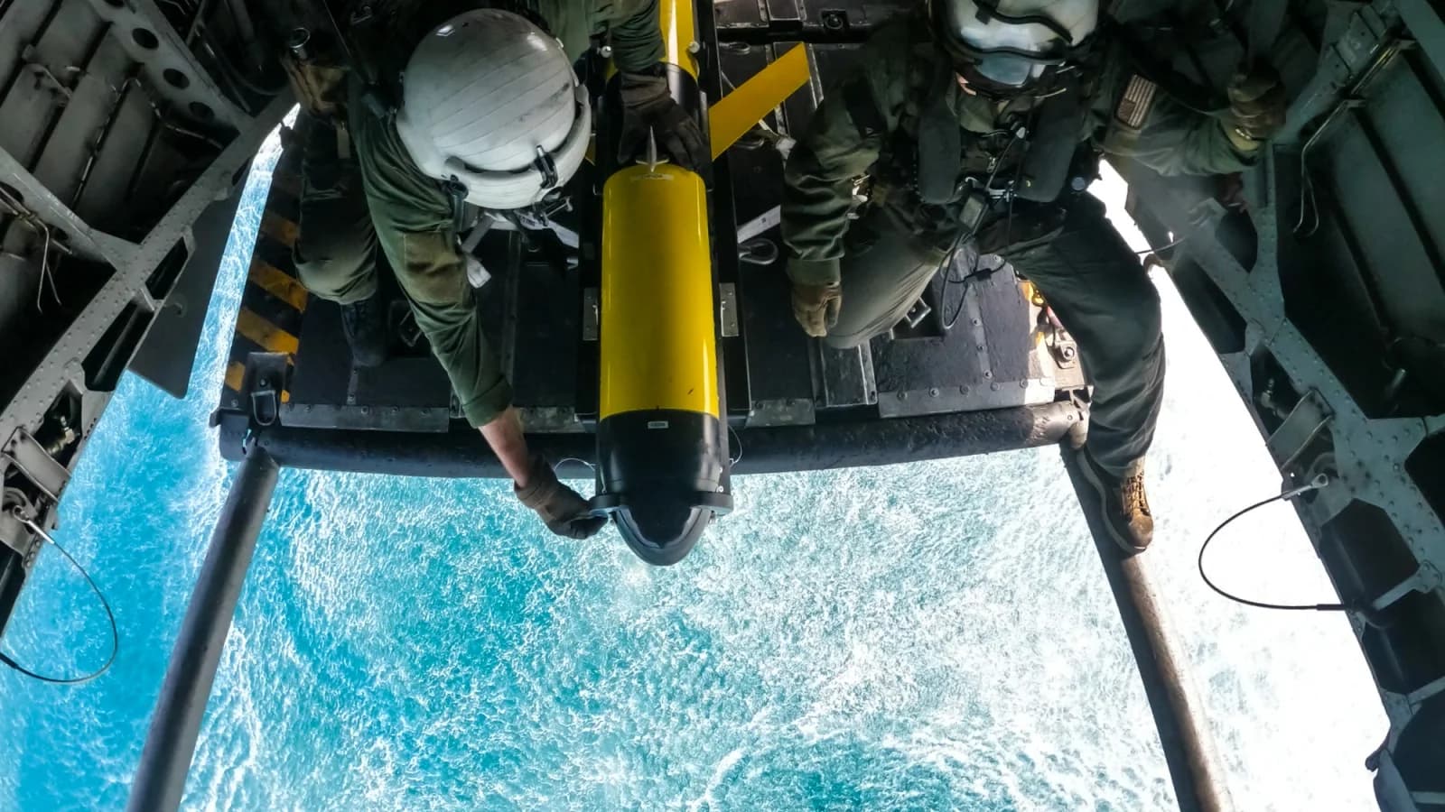 Crew handle a yellow Slocum glider at a helicopter ramp during a 2023 Arabian Sea proof of concept