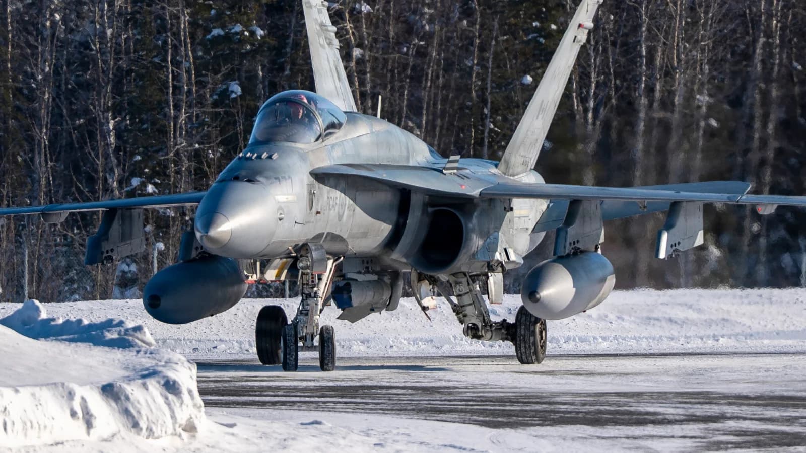A Royal Canadian Air Force CF 18 taxis on a snowy Eielson flight line during ARCTIC EDGE in March 2026