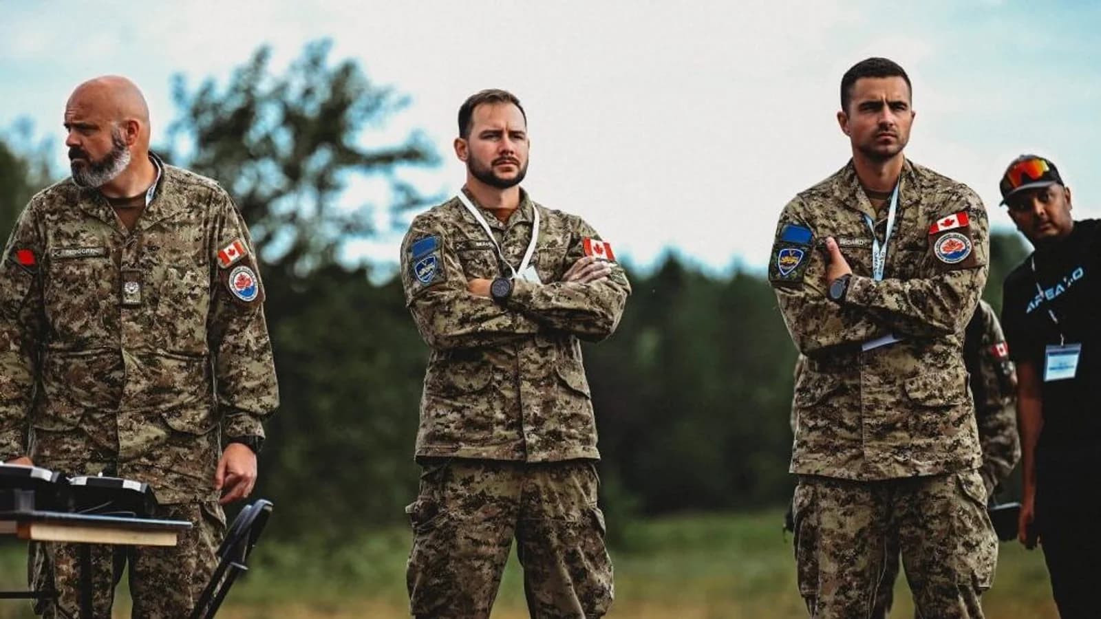 Three Canadian Armed Forces personnel watch demonstrations at RED COBALT at Area X.O Killaloe